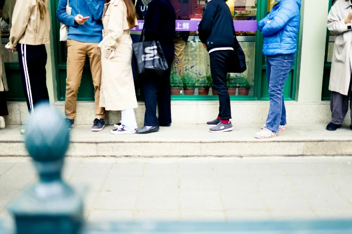 a group of people standing on a sidewalk